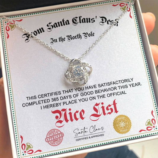 A sterling silver pendant necklace with a love knot design, presented in a box with a handwritten note from Santa Claus, indicating completion of a good behavior list for the year.